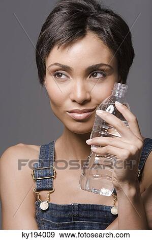 Close-up of a woman holding a water bottle View Large Photo Image Stock Photo - Close-up of a woman holding a water bottle. Fotosearch