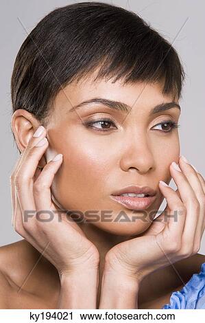 Close-up of a woman with her hands on her chin View Large Photo Image Stock Image - Close-up of a woman with her hands on her chin. Fotosearch
