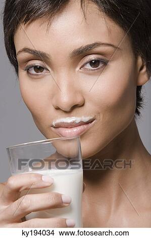 Portrait of a woman drinking milk from a glass View Large Photo Image Picture - Portrait of a woman drinking milk from a glass. Fotosearch