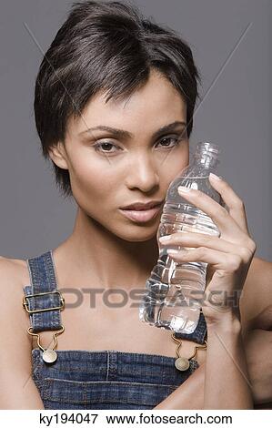 Stock Photo - Portrait of a woman holding a water bottle. Fotosearch