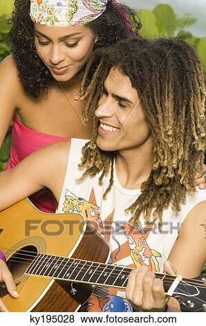 Couple playing a guitar View Large Photo Image Stock Photo - Couple playing a guitar. Fotosearch