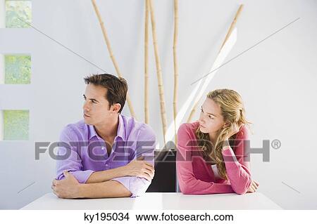 Couple sitting side by side and ignoring each other View Large Photo Image Picture - Couple sitting side by side and ignoring each other. Fotosearch