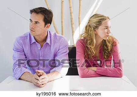 Couple sitting side by side and ignoring each other View Large Photo Image Stock Photograph - Couple sitting side by side and ignoring each other. Fotosearch