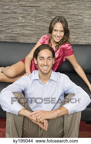 Portrait of a couple sitting in a living room View Large Photo Image Picture - Portrait of a couple sitting in a living room. Fotosearch