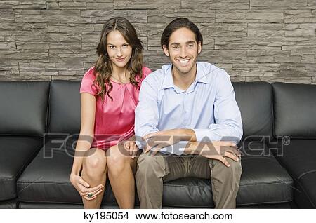 Portrait of a couple sitting on a couch View Large Photo Image Picture - Portrait of a couple sitting on a couch. Fotosearch