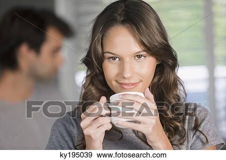 Woman holding a cup of tea and day dreaming View Large Photo Image Stock Photo - Woman holding a cup of tea and day dreaming. Fotosearch