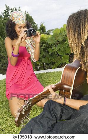 Woman taking a picture of a man playing a guitar View Large Photo Image Stock Photo - Woman taking a picture of a man playing a guitar. Fotosearch