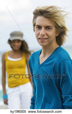 Teenage boy standing with a girl on the beach View Large Photo Image Stock Photography - Teenage boy standing with a girl on the beach. Fotosearch