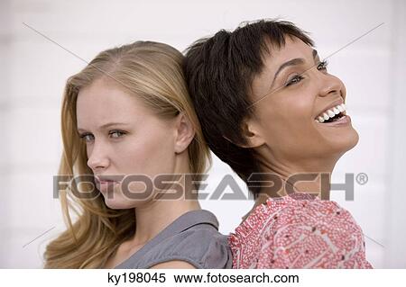Stock Photography - Close-up of two women back to back. Fotosearch
