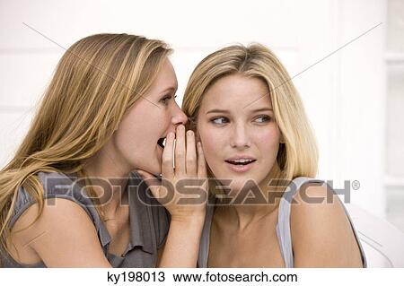 Stock Image - Close-up of two women gossiping. Fotosearch