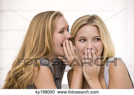 Stock Image - Close-up of two women gossiping. Fotosearch