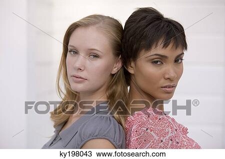 Stock Image - Portrait of two women looking displeased. Fotosearch