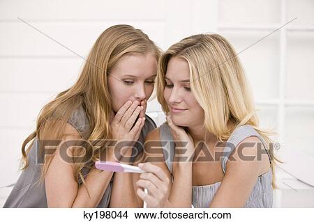 Two women looking at a pregnancy test stick View Large Photo Image Picture - Two women looking at a pregnancy test stick. Fotosearch