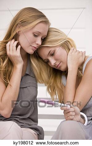 Two women looking at a pregnancy test stick View Large Photo Image Stock Image - Two women looking at a pregnancy test stick. Fotosearch