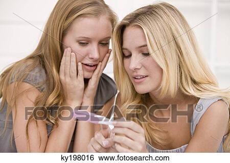 Two women looking at a pregnancy test stick View Large Photo Image Stock Photograph - Two women looking at a pregnancy test stick. Fotosearch