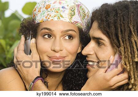 Close-up of a couple using mobile phones View Large Photo Image Picture - Close-up of a couple using mobile phones. Fotosearch