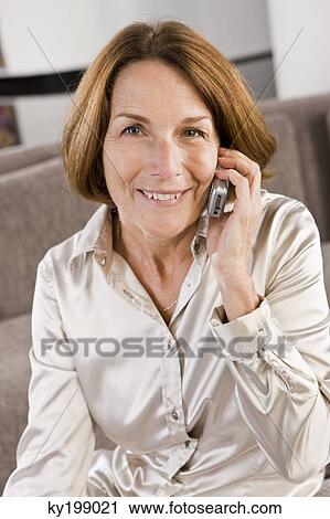 Portrait of a woman talking on a mobile phone View Large Photo Image Stock Image - Portrait of a woman talking on a mobile phone. Fotosearch