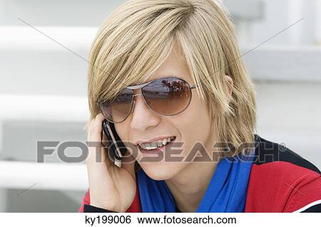Teenage boy talking on a mobile phone View Large Photo Image Stock Photograph - Teenage boy talking on a mobile phone. Fotosearch
