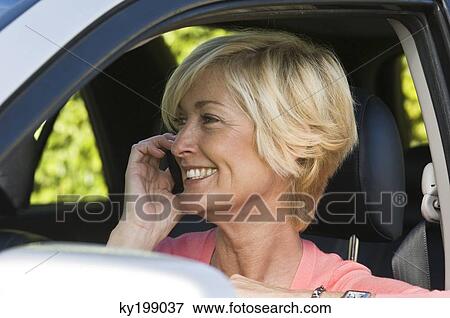 Woman in a car and talking on a mobile phone View Large Photo Image Stock Photo - Woman in a car and talking on a mobile phone. Fotosearch