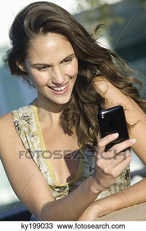 Woman reading text message on a mobile phone View Large Photo Image Stock Image - Woman reading text message on a mobile phone. Fotosearch