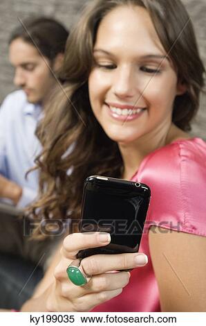Woman reading text message on a mobile phone View Large Photo Image Stock Photography - Woman reading text message on a mobile phone. Fotosearch