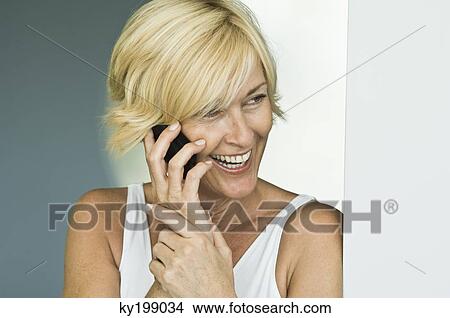 Woman talking on a mobile phone and laughing View Large Photo Image Picture - Woman talking on a mobile phone and laughing. Fotosearch
