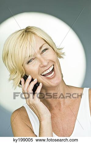Woman talking on a mobile phone and laughing View Large Photo Image Stock Photography - Woman talking on a mobile phone and laughing. Fotosearch