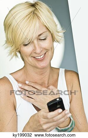 Woman text messaging and smiling View Large Photo Image Stock Image - Woman text messaging and smiling. Fotosearch