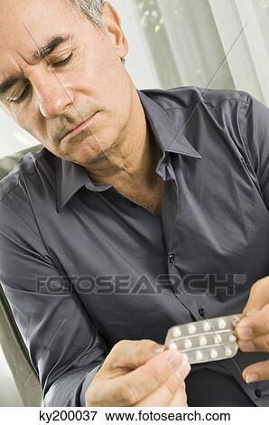 Close-up of a man holding a blister pack View Large Photo Image Stock Photo - Close-up of a man holding a blister pack. Fotosearch