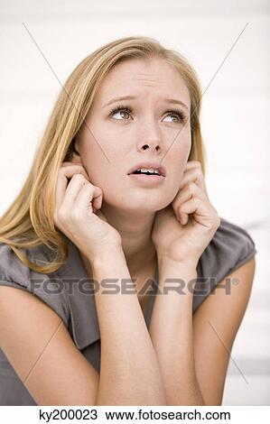 Close-up of a woman holding her ears View Large Photo Image Stock Image - Close-up of a woman holding her ears. Fotosearch