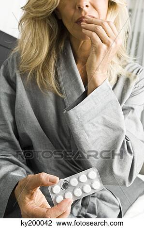 Stock Image - Close-up of a woman taking medicine. Fotosearch