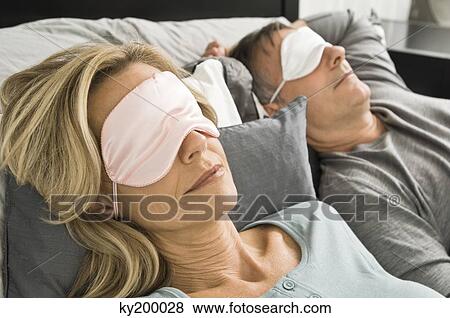Couple sleeping in bed wearing eye masks View Large Photo Image Stock Photo - Couple sleeping in bed wearing eye masks. Fotosearch