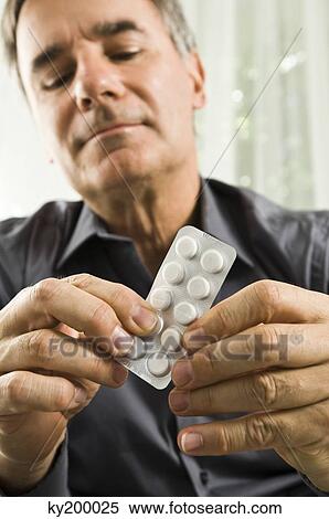 Man holding a blister pack View Large Photo Image Stock Photography - Man holding a blister pack. Fotosearch
