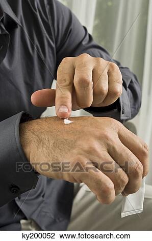 Mid section view of a man applying medicine on his hand View Large Photo Image Stock Image - Mid section view of a man applying medicine on his hand. Fotosearch