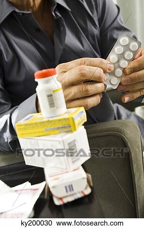 Mid section view of a man holding a blister pack View Large Photo Image Stock Image - Mid section view of a man holding a blister pack. Fotosearch