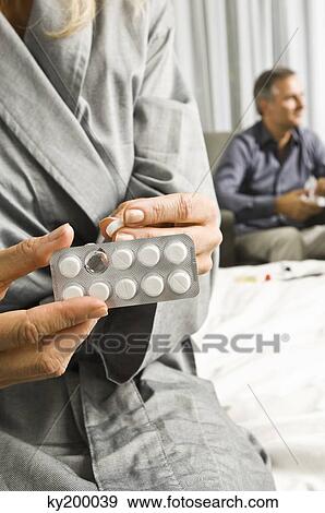Mid section view of a woman holding a blister pack View Large Photo Image Stock Photo - Mid section view of a woman holding a blister pack. Fotosearch