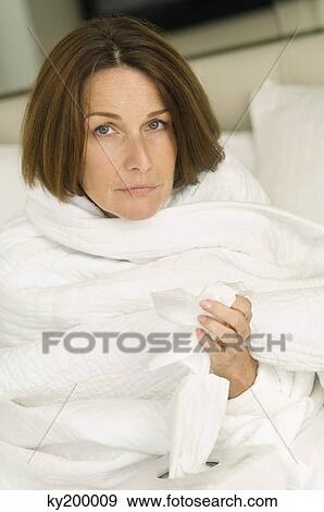 Portrait of a woman wrapped in a blanket and holding tissue paper View Large Photo Image Stock Photo - Portrait of a woman wrapped in a blanket and holding tissue paper. Fotosearch