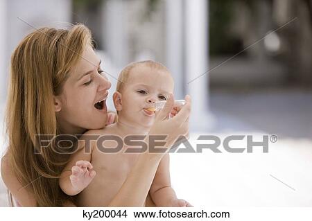Picture - Woman giving medicine to her daughter. Fotosearch