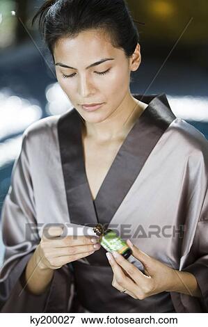 Woman holding a bottle of aromatherapy oil View Large Photo Image Stock Photo - Woman holding a bottle of aromatherapy oil. Fotosearch