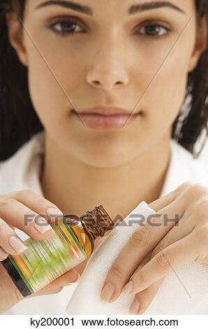 Stock Image - Woman holding a napkin and an oil bottle. Fotosearch