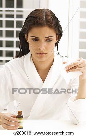Woman holding a napkin and an oil bottle View Large Photo Image Stock Photo - Woman holding a napkin and an oil bottle. Fotosearch