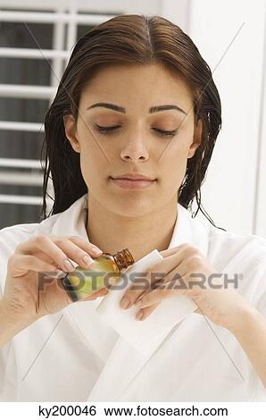 Woman holding a napkin and an oil bottle View Large Photo Image Stock Photograph - Woman holding a napkin and an oil bottle. Fotosearch
