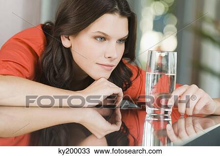Woman looking at a glass of water View Large Photo Image Stock Image - Woman looking at a glass of water. Fotosearch