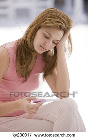 Woman looking at a pregnancy test stick View Large Photo Image Stock Photo - Woman looking at a pregnancy test stick. Fotosearch