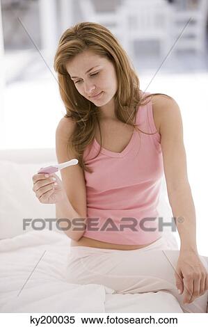 Woman looking at a pregnancy test stick View Large Photo Image Stock Photography - Woman looking at a pregnancy test stick. Fotosearch