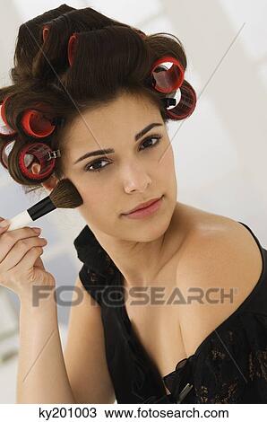 Portrait of a woman applying blusher on her face View Large Photo Image Stock Image - Portrait of a woman applying blusher on her face. Fotosearch