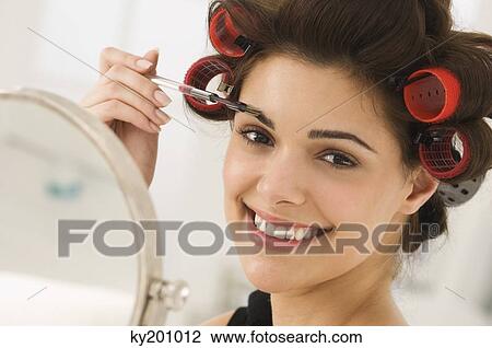 Portrait of a woman tweezing eyebrows View Large Photo Image Stock Image - Portrait of a woman tweezing eyebrows. Fotosearch