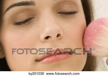 Woman applying blusher on her face View Large Photo Image Stock Image - Woman applying blusher on her face. Fotosearch
