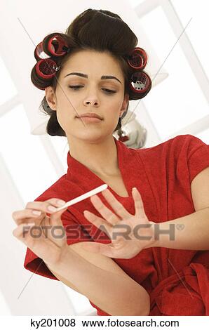 Woman filing nails with a nail file View Large Photo Image Stock Photo - Woman filing nails with a nail file. Fotosearch