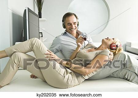 Couple listening to music with headphones and smiling View Large Photo Image Stock Photography - Couple listening to music with headphones and smiling. Fotosearch